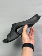 Black slide sandal with curved upper cutout and chunky tread outsole
