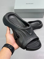 Black Balenciaga slide sandals with thick molded sole and cutout upper