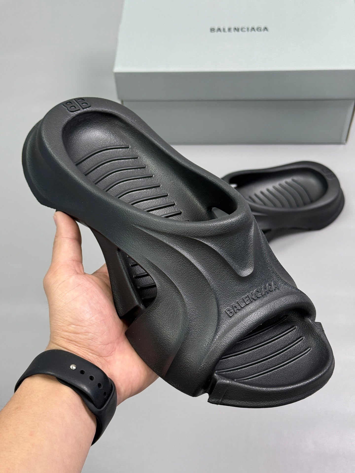 Black Balenciaga slide sandals with thick molded sole and cutout upper