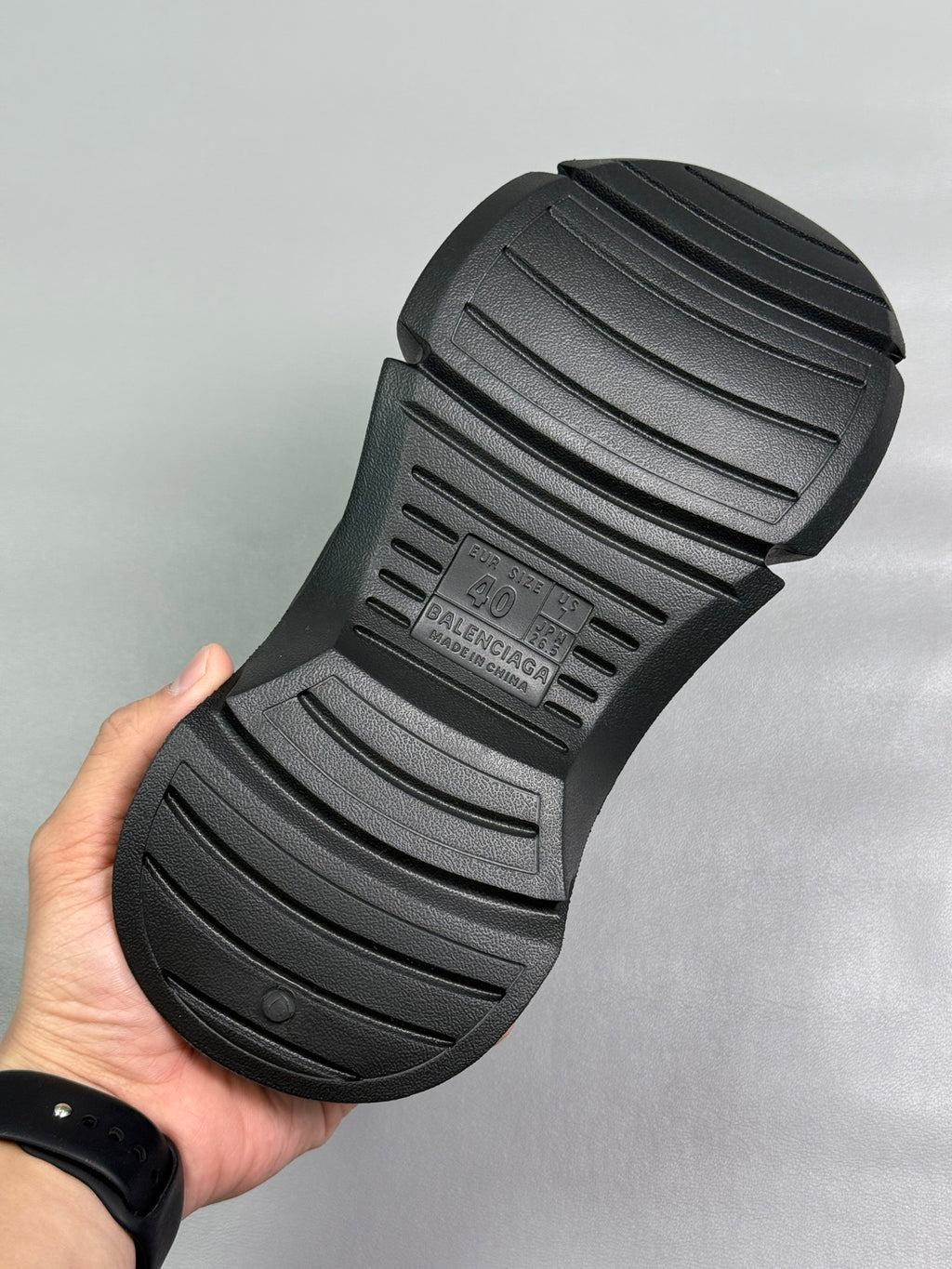 Black slide sandal outsole with deep tread lines and BALENCIAGA branding