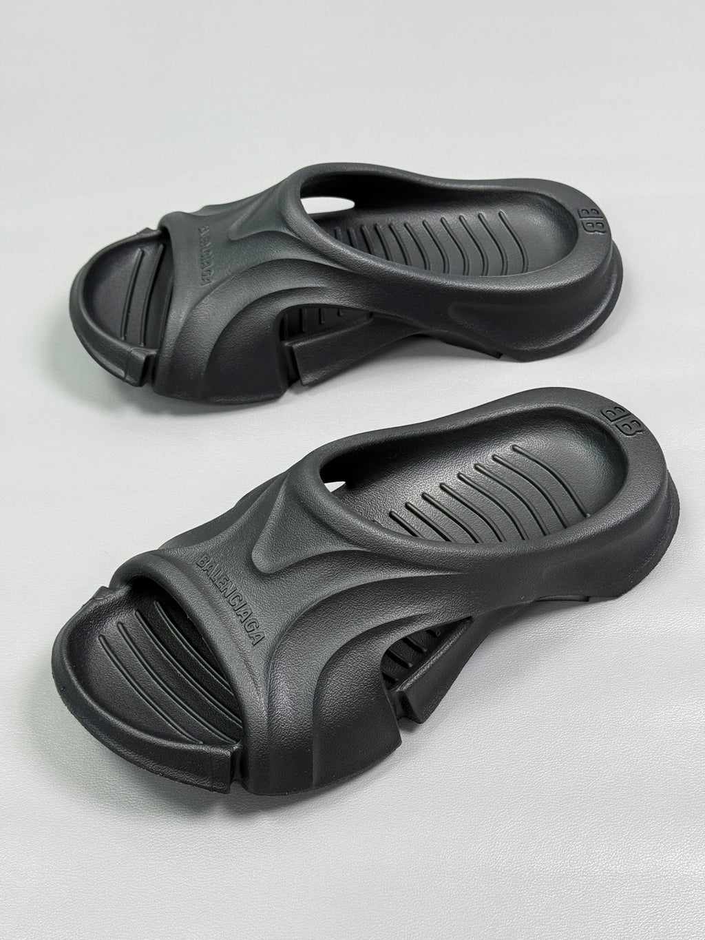 Pair of black slide sandals showing molded straps and vented footbeds