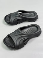 Pair of black slide sandals showing molded straps and vented footbeds