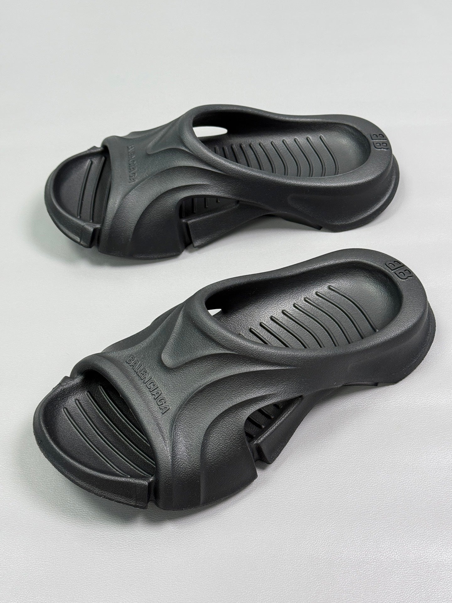 Pair of black slide sandals showing molded straps and vented footbeds