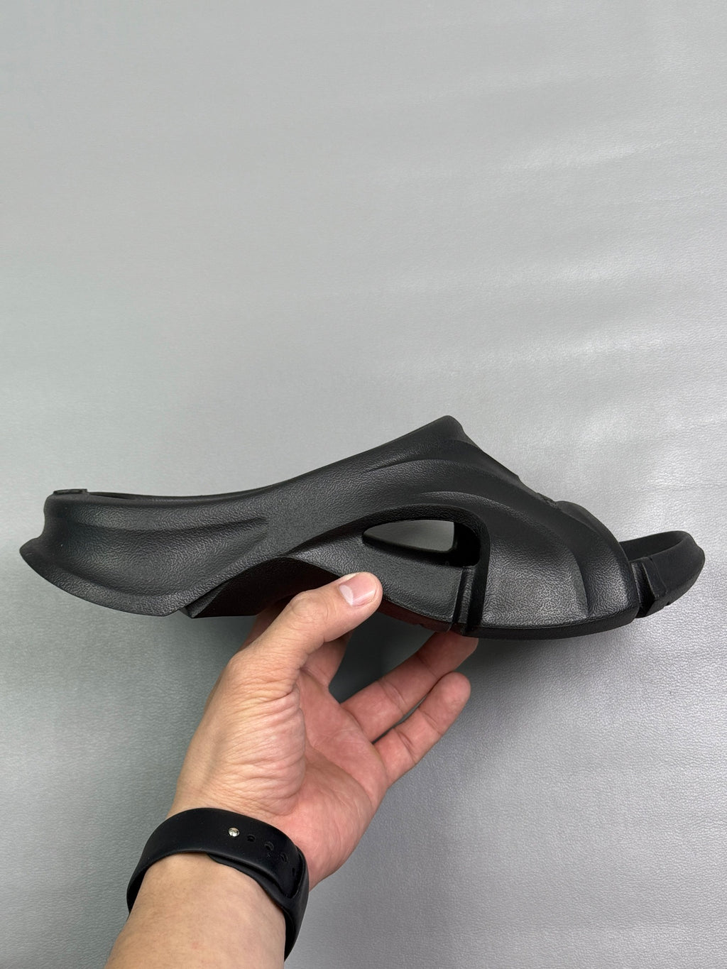 Black slide sandal with open toe, chunky strap, and sculpted outsole