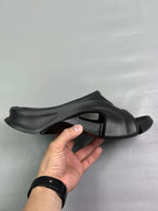 Black slide sandal with open toe, chunky strap, and sculpted outsole
