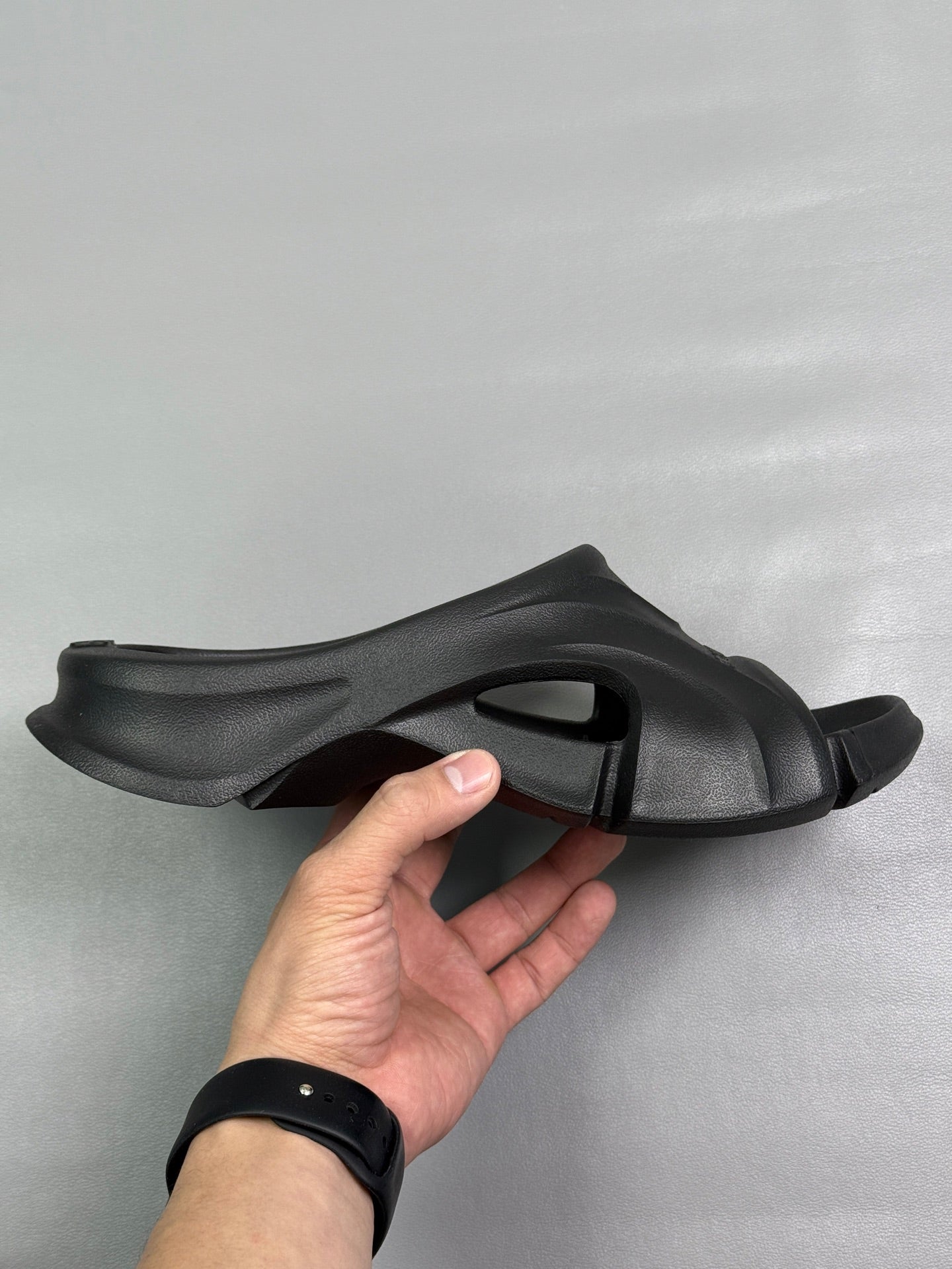 Black slide sandal with open toe, chunky strap, and sculpted outsole