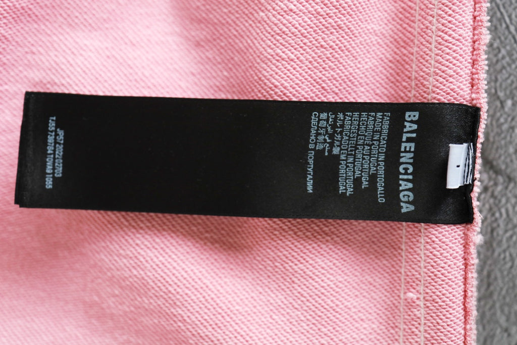 Black brand label on pink track shorts with Balenciaga text