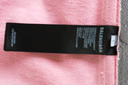 Black brand label on pink track shorts with Balenciaga text