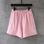 Pink Balenciaga track shorts with elastic waistband and side stripe accents