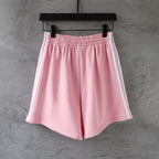 Pink Balenciaga track shorts front view with elastic waistband and white side stripes