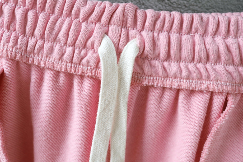Pink track shorts waistband with elastic top and off-white drawstring