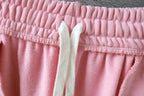 Pink track shorts waistband with elastic top and off-white drawstring