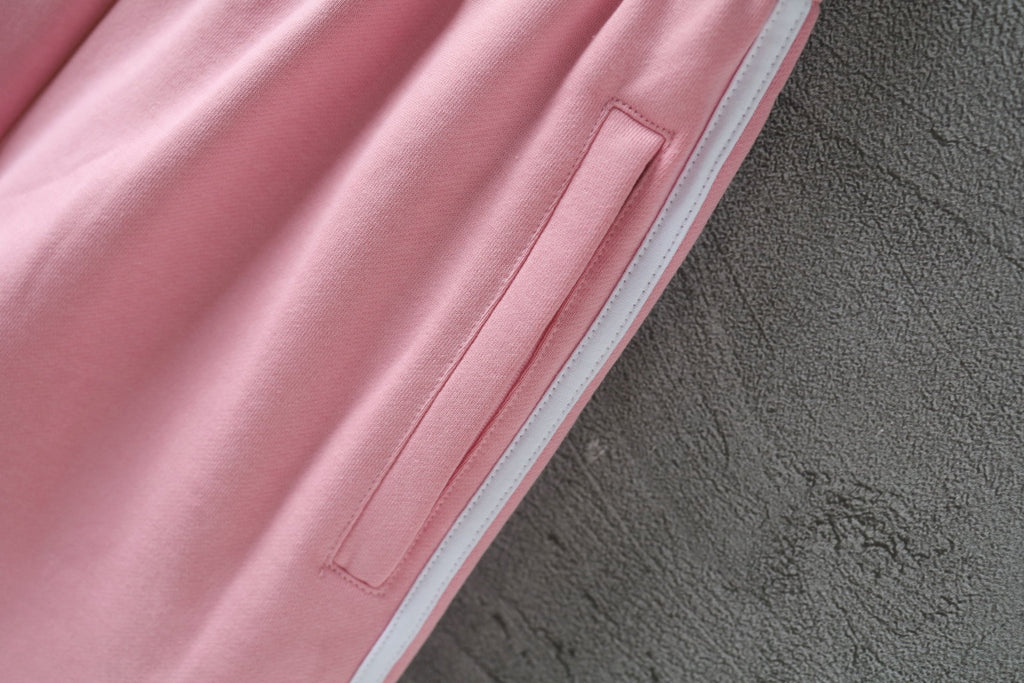 Pink track shorts side seam with white triple stripe and box-stitched detail