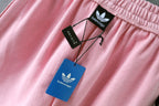 Pink track shorts with hanging Balenciaga tags and elastic waistband
