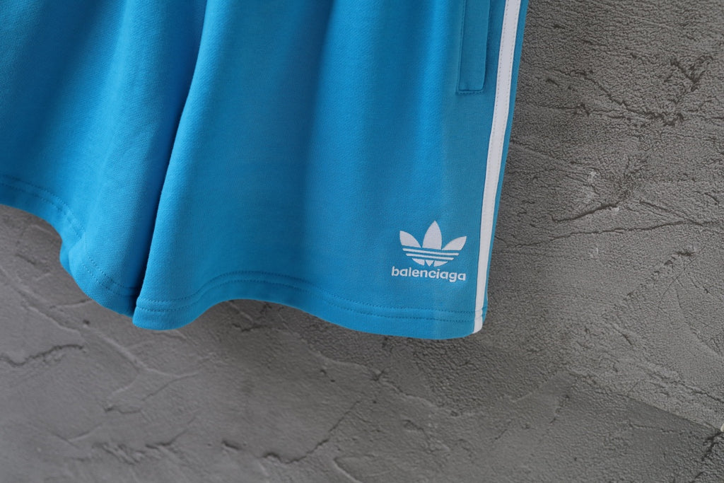 Balenciaga blue shorts with white logo at hem and striped side seam