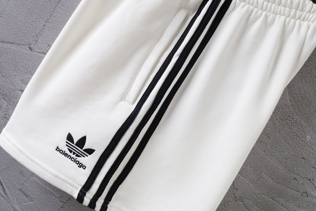 White shorts with black side stripes and Balenciaga logo patch