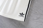White Balenciaga shorts hem with small logo and black side stripe