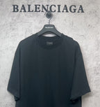 Black Balenciaga T-shirt close front view on hanger, crew neck and short sleeves.