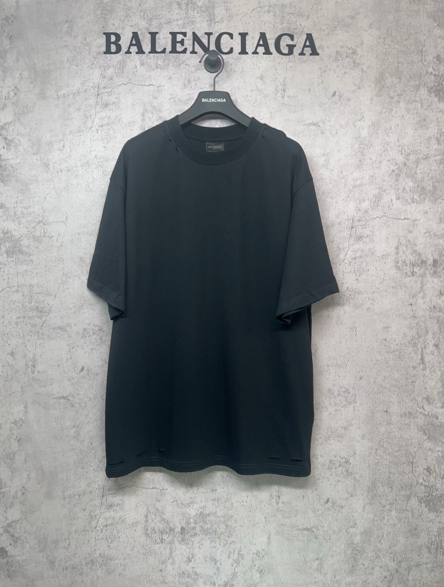 Black Balenciaga T-shirt on hanger, short sleeves and crew neck, plain front.