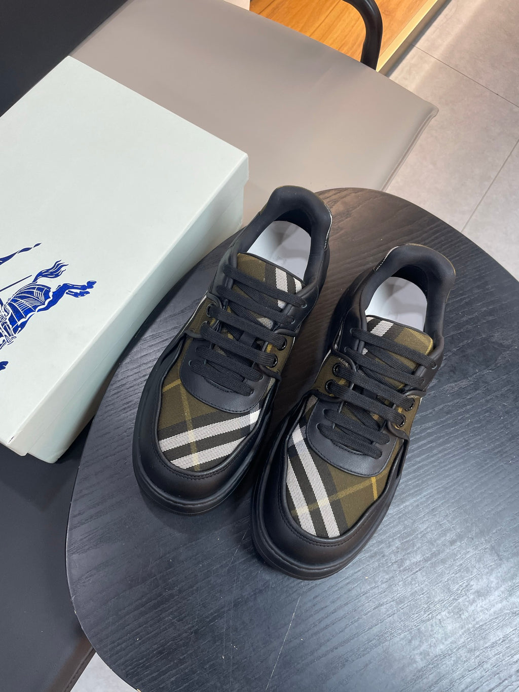 Burberry lace-up sneakers with black uppers and plaid check side stripe, pair view
