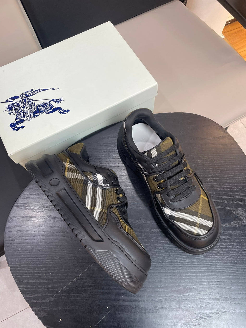 Burberry sneakers pair, black uppers with yellow plaid side panels and lace-up