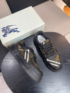 Burberry sneakers pair, black uppers with yellow plaid side panels and lace-up