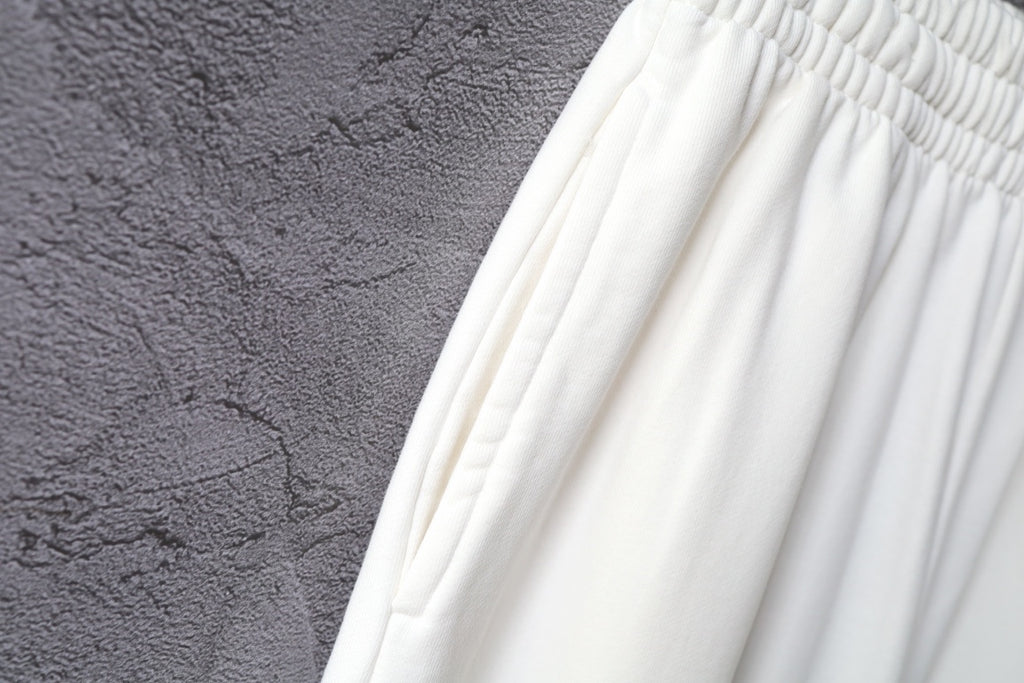 White pants fabric with soft gathers across the upper thigh