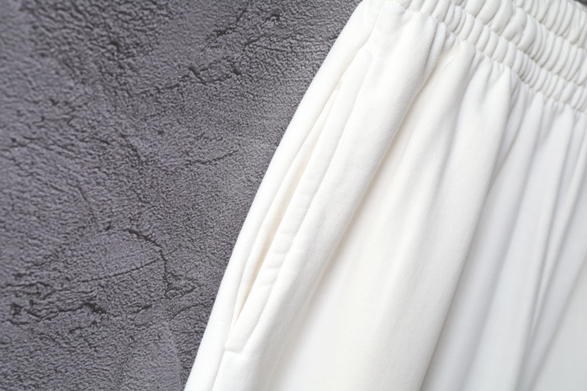 White pants fabric with soft gathers across the upper thigh