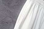 White pants fabric close-up with gathered seam near waist
