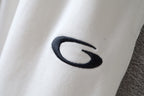 White pants leg with oval dark logo embroidery