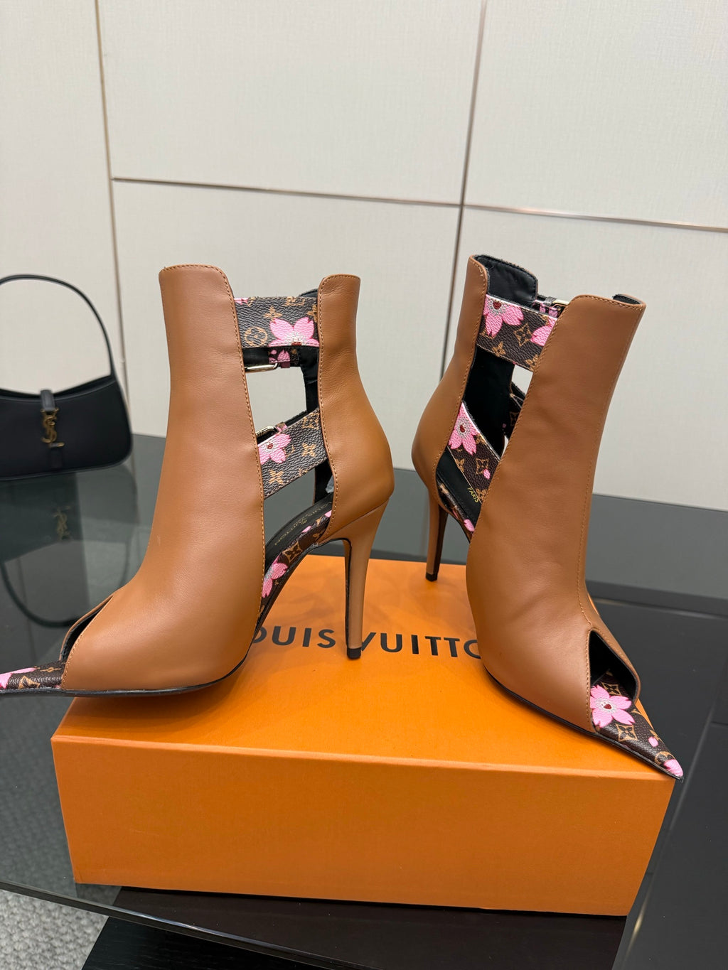 Women's Louis Vuitton tan ankle boots with pointed toe, pink floral detail, and gold buckle.
