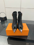 Black heeled ankle boots with floral straps and gold-tone buckles, pointed toe.
