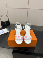 Women's heeled sandals in white with pink floral straps, stiletto heel and ankle ties