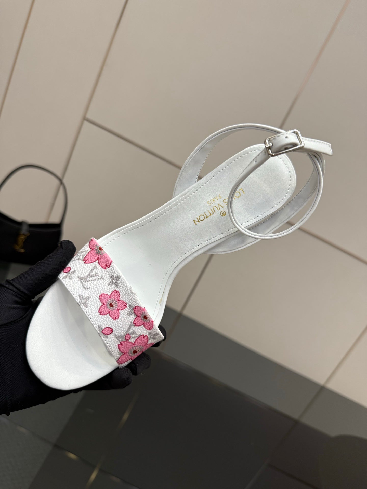 Women's white sandal with pink floral strap and circular ankle buckle detail