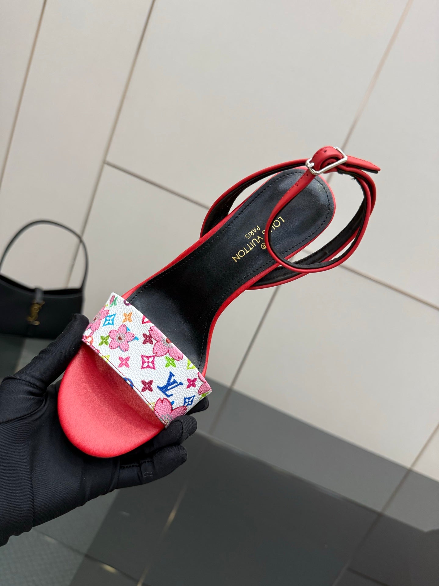 Louis Vuitton women’s red sandal with black heel and floral-pattern strap detail shown close-up