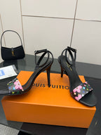 Black stiletto heeled slingback sandals with multicolor floral monogram fabric details