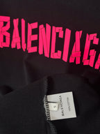 Black T-shirt with pink BALENCIAGA print and size label