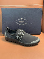 Prada unisex dark gray slip-on sneakers with PRADA lettering and grippy outsole.