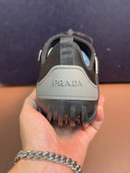 Prada unisex dark gray slip-on sneakers with PRADA logo on heel.