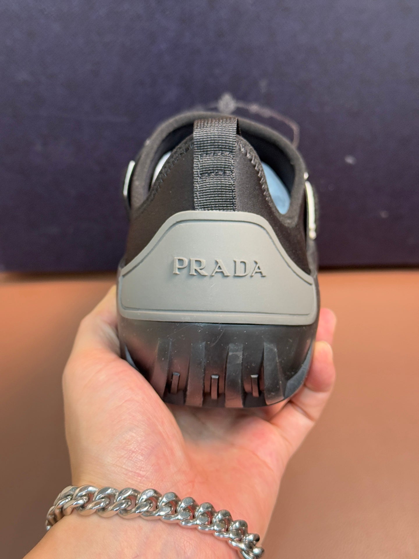 Prada unisex dark gray slip-on sneakers with PRADA logo on heel.