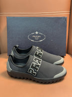 Prada unisex dark gray slip-on sneakers with PRADA strap detail and thick sole.
