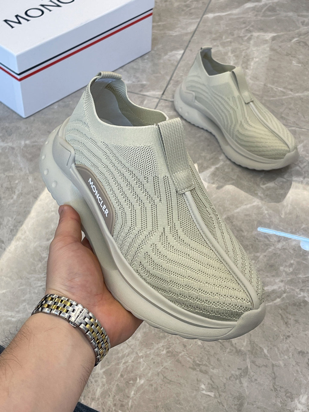 Moncler knit slip-on sneakers, light green, hand-held side view with logo