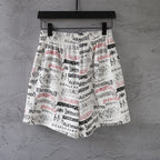 White printed shorts with black and red repeating logo text, elastic waist