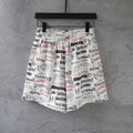 White printed shorts with black and red logo pattern, elastic waistband