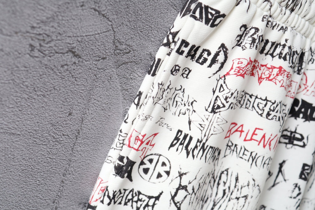 Close-up of white printed shorts with black and red logo text at waistband