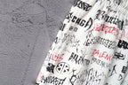 Close-up of white printed shorts with black and red logo text at waistband
