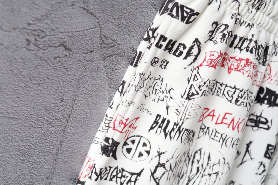 Close-up of white printed shorts with black and red logo text at waistband