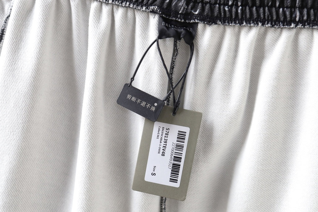 Balenciaga shorts with drawstring and brand tags on light-colored fabric.
