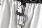 Balenciaga shorts with drawstring and brand tags on light-colored fabric.