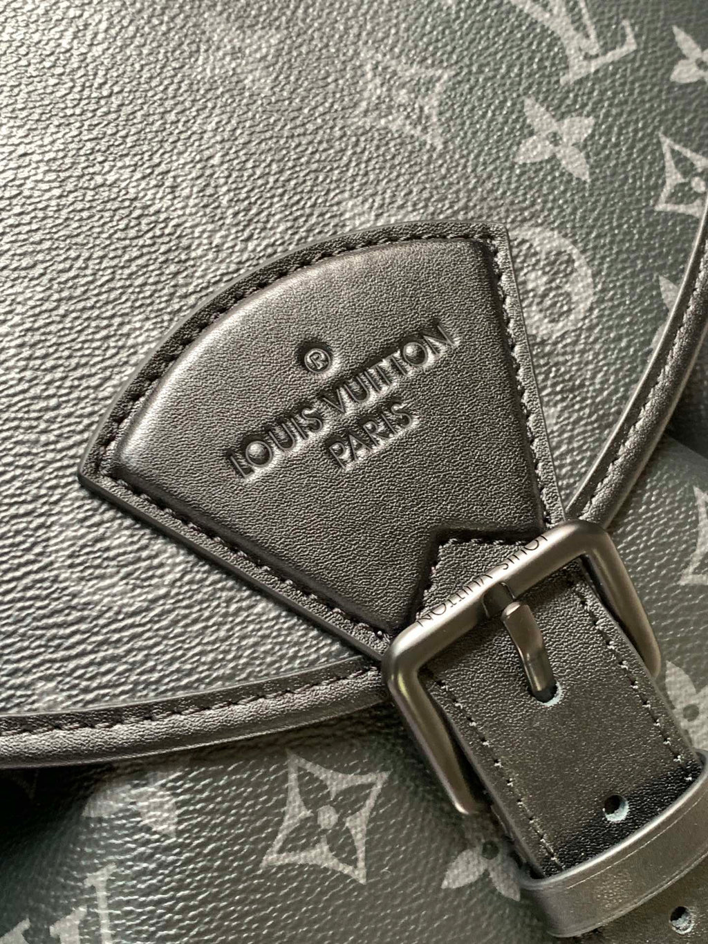 Louis Vuitton belt hardware patch with “Louis Vuitton Paris” lettering on dark strap